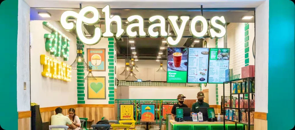 Chaayos café with illuminated signage, a service counter and seating